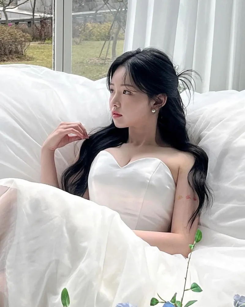 흰 소파에 기대 앉은 웨딩드레스 차림의 신부